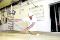 The curds, floating in whey, are stirred and cooked for over an hour